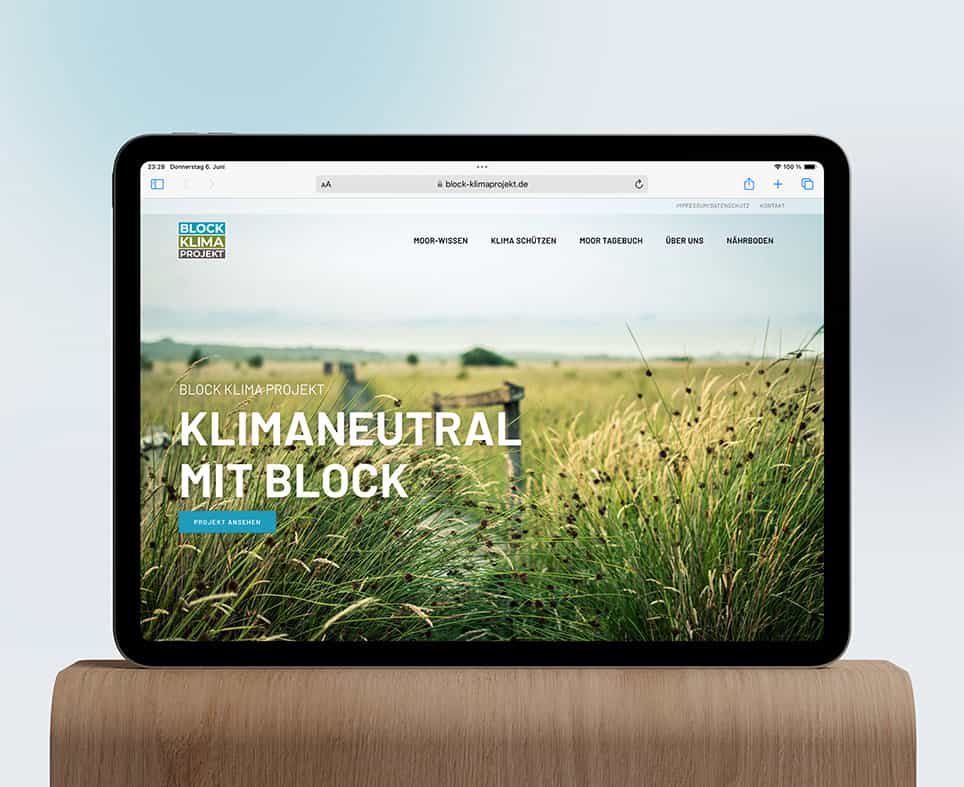 Foto, dass die Website des Unternehmens BLOCK KLIMAPROJEKT auf einem iPad zeigt, das auf einem Holztisch steht